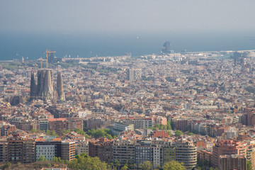 Fototapeta premium Barcelona, Spain - April, 2019: View of Barcelona city and costline in spring from the Bunkers in Carmel neighborhood. Few building stand out like sagrada familia and Agbar tower