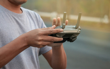 hands with remote controller of drone outside.