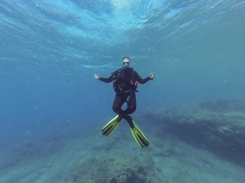 Young female scuba diver in the lotus yoga position  during a dive in Atlantic ocean