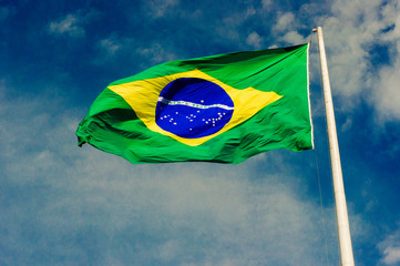 Flag of Brazil balancing on blue Sky