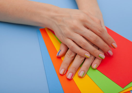 Modern stylish manicure rainbow or summer mood, on a blue table with colored envelopes top view
