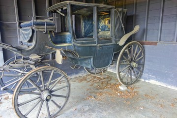 Fototapeta na wymiar Rotting Ruined Vintage Old Horse Carriage in Abandoned Rural Farm Barn