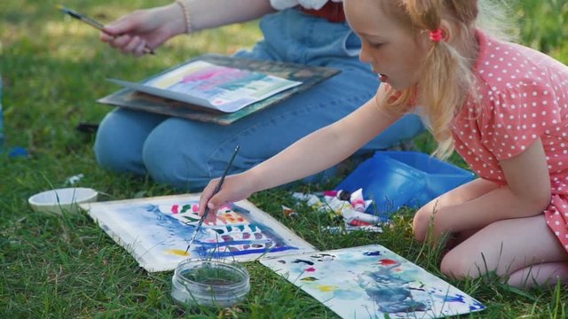 Little Girl Attending Painting Workshop in a Park. Child drawing with watercolor with Teacher Outdoors. Creativity Inspiration Expression Concept
