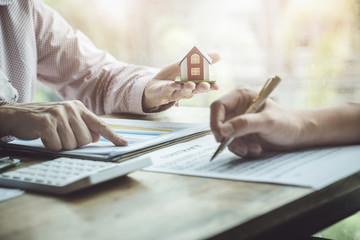 Real estate agents discussing about loans and interest rates for buying houses for customers who...