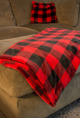 Red plain throw laying on brown ottoman