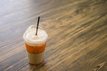 Thai iced tea on wood table in cafe.