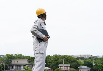 新興住宅街に立つヘルメットの男性　宅地開発　現地調査　用地買収