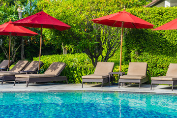 Beautiful umbrella and chair around outdoor swimming pool in hotel resort for holiday vacation travel