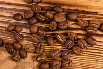 Scattered coffee beans on a wooden table. Top view