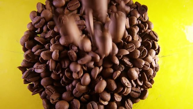 Slow Motion Of Pouring Coffee Beans Into A Glass Isolated On Yellow Bacground.
