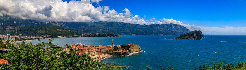 Fototapeta na wymiar Panoramic view of Budva Old Town with an ancient Citadel and Adriatic Sea with mountains in the background in Montenegro