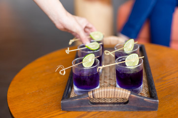 Summer fresh drink butterfly pea drink and slice of lime on a bamboo tray.