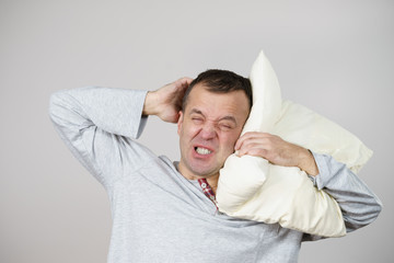 Man sleepy tired with pillow on grey