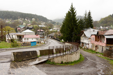 Fototapeta na wymiar Street in village Mzetamze, Borjomi nearby, in rayny day. Climatic resort area in Georgia
