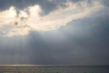 The sea surface in the rays of sunlight on a cloudy day. The sea in the rays of the sun coming...