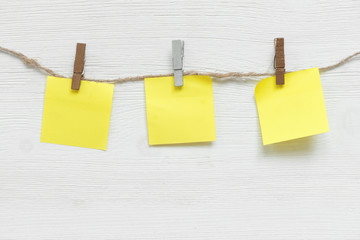 Blank paper stickers with copy space on a clothespin on a rope on a white table background. To do...