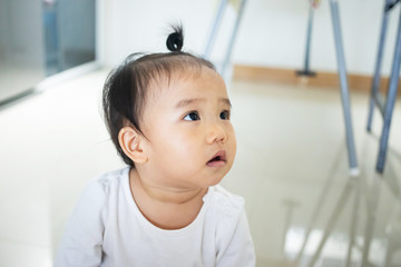 Portrait of adorable Asian baby girl looking at something