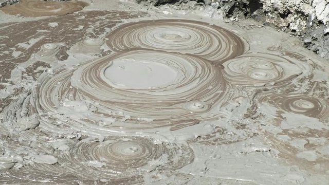 Crater of mud volcano bursting bubbles with natural gas. Famous nature landmark of Gobustan area near Baku in Azerbaijan