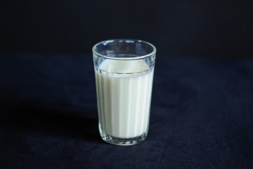photo a glass of milk stands on a black tablecloth