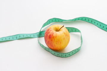 apple and measuring tape isolated on white