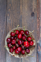 fresh sweet cherries in a bowl on wooden table