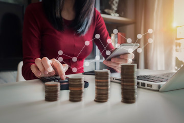 businesswomen holding coins putting in glass with using  calculator to calculate concept saving money for finance accounting.