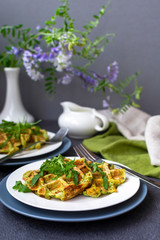Homemade fresh baked zucchini waffles, served with fresh arugula on white plate