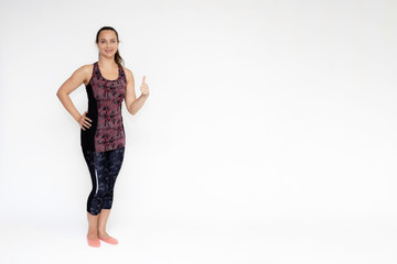 Full-length portrait on white background of beautiful pretty fitness woman girl in fashionable sportswear standing exercising in different poses, showing hands. Smiles Stylish trendy youth.