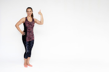 Full-length portrait on white background of beautiful pretty fitness woman girl in fashionable sportswear standing exercising in different poses, showing hands. Smiles Stylish trendy youth.