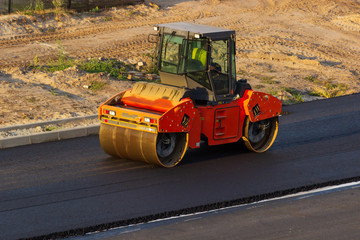 industrial landscape with rollers that rolls a new asphalt on the road. Repair work, complicated transport movement.