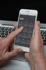 Business old man holding smartphone with calendar app