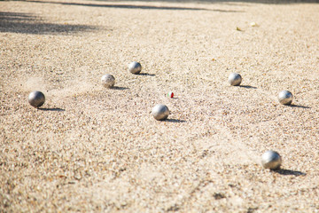 Silver Petanque or Bocce balls on gravel ground with a blur background
