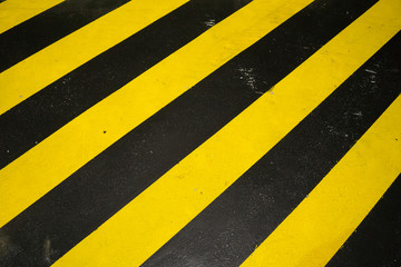 Fototapeta premium Black and yellow caution warning pattern background on the floor