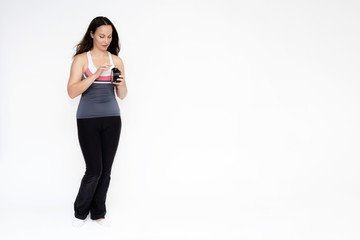 Fototapeta premium Full-length portrait on white background of beautiful pretty fitness girl woman in sports uniform, standing with different emotions in different poses, showing hands. Smiles Stylish trendy youth.