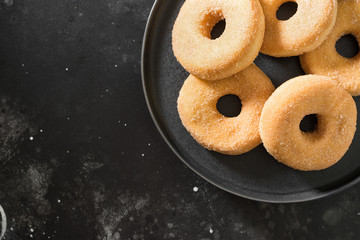 Donuts sprinkled with sugar. Dark background