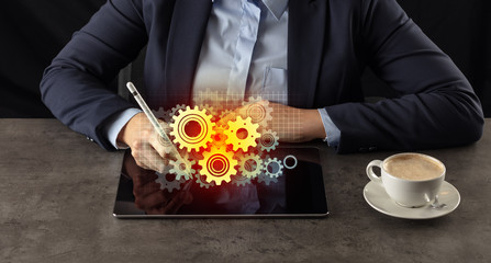 Business woman working on tablet with setting and gear concept