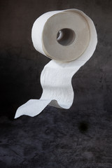 Toilet paper roll on dark background in free fall.The Topic Of Hygiene