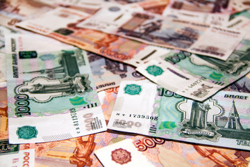 Fototapeta premium Banknotes of the Russian currency of different denominations scattered on the table - a sign of wealth and prosperity.