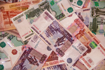 Banknotes of the Russian currency of different denominations scattered on the table - a sign of wealth and prosperity.