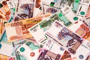 Banknotes of the Russian currency of different denominations scattered on the table - a sign of wealth and prosperity.
