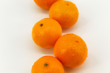 On a light background is a little fruit, orange, tangerines