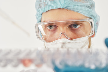 Scientist dropping liquid with pipette into cells