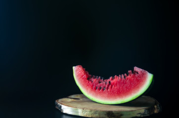 sliced juicy ripe watermelon on a dark background for the menu