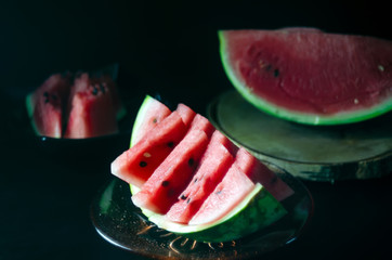 sliced juicy ripe watermelon on a dark background for the menu
