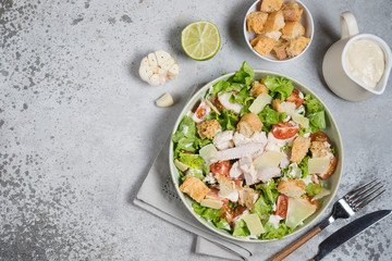 Caesar salad with chicken, Parmesan and wheat croutons on a vintage grey background. Light diet...