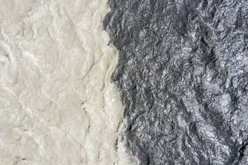 amazing view of the confluence of two rivers with different colors of water. The two mountain rivers, the Black Aragvi and the White Aragvi, do not mix water at the confluence. Pasanauri Georgia.