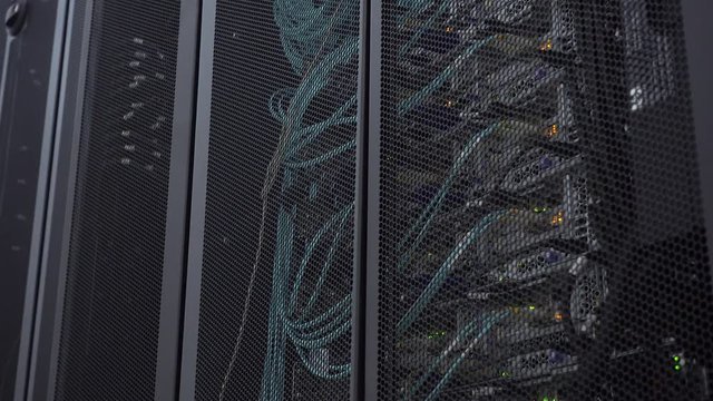Optical server is located behind the iron door of the data center server room. View through the round vents of the cabinet wall.