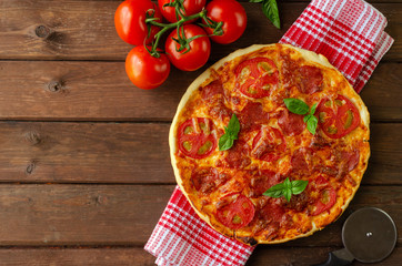 Homemade spicy pizza with sausage and tomato.