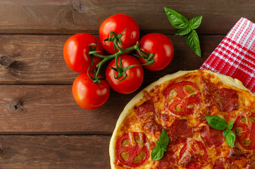 Homemade spicy pizza with sausage and tomato.