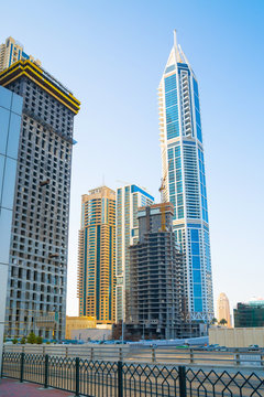 Dubai marina skyscrapers at sunset. View against of blue sky from the Amaar walk. Apartments, hotels and office buildings of UAE